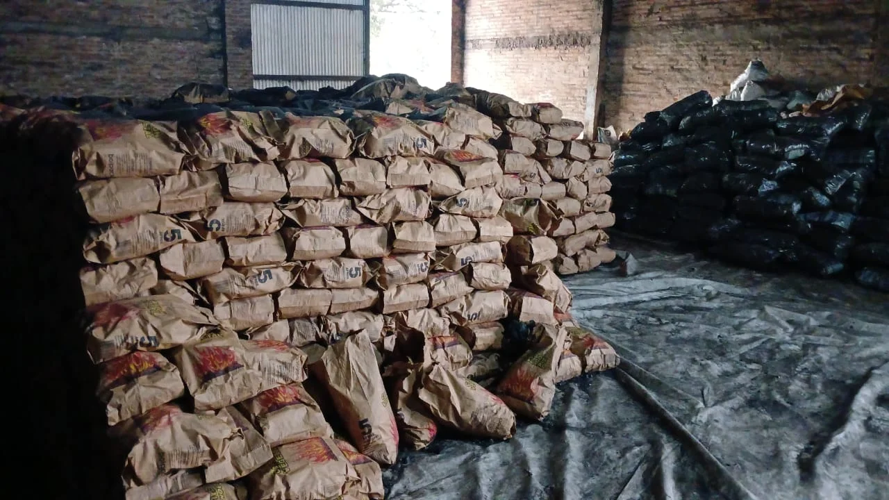 Depósito con bolsas kraft de carbón vegetal de 5 kg apiladas